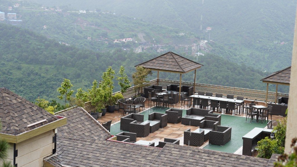 Open-air dining terrace above misty mountains