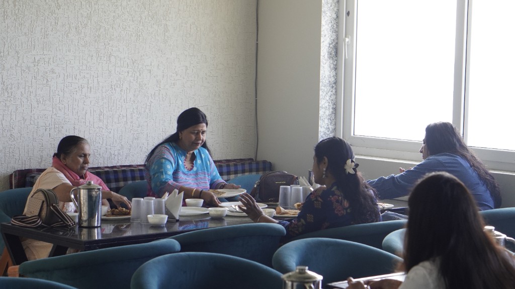 Guests seated together over lunch in a bright dining room