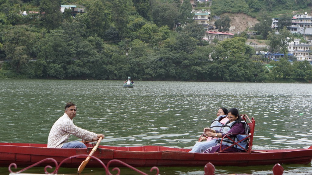 Guests on a red rowing boat crossing a quiet lake