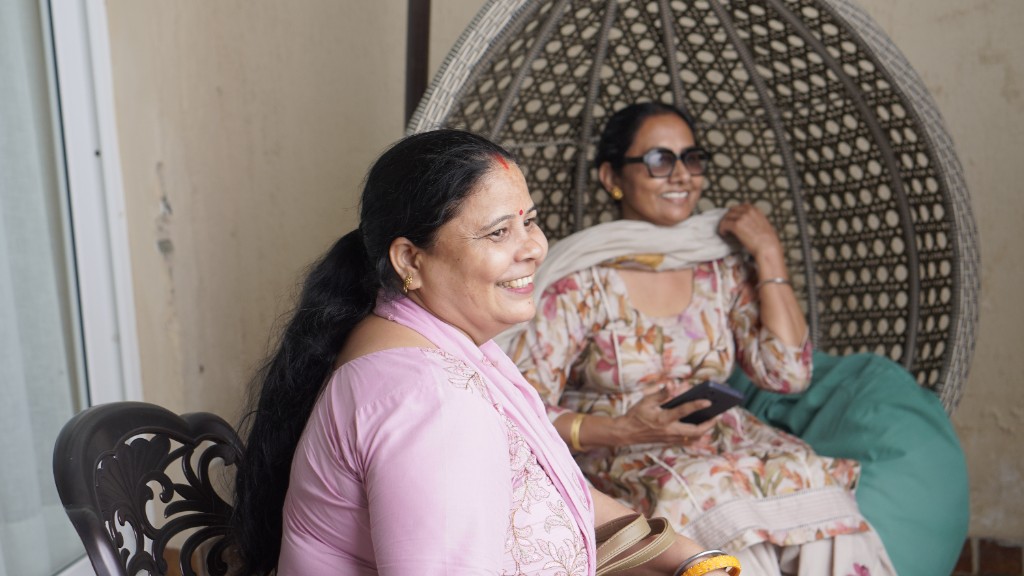 Two guests relaxing together, one smiling in quiet conversation