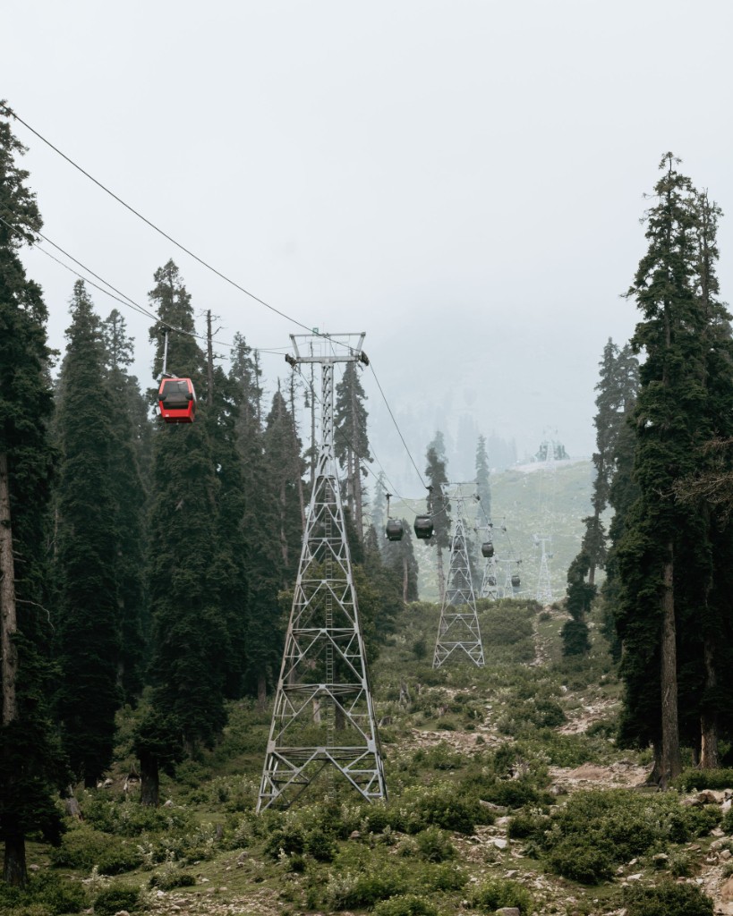 Gulmarg Gondola cable car ascending over green alpine meadow
