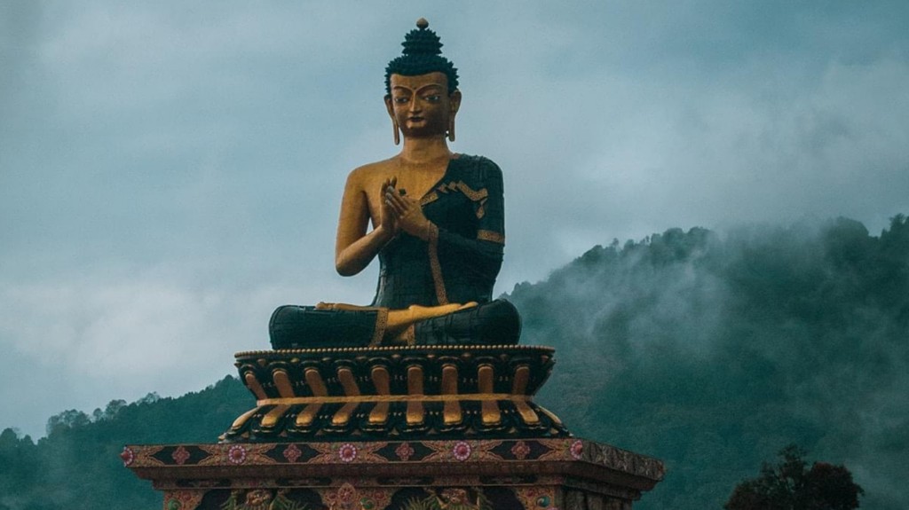 Majestic Northeast Retreat - golden Buddha statue overlooking misty Sikkim mountains