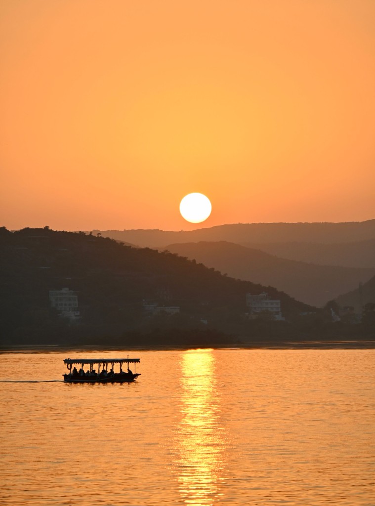 Sunset boat ride on Lake Pichola with City Palace turning gold